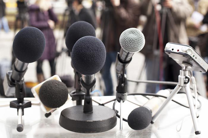 Mikrofone mit Presse im Hintergrund